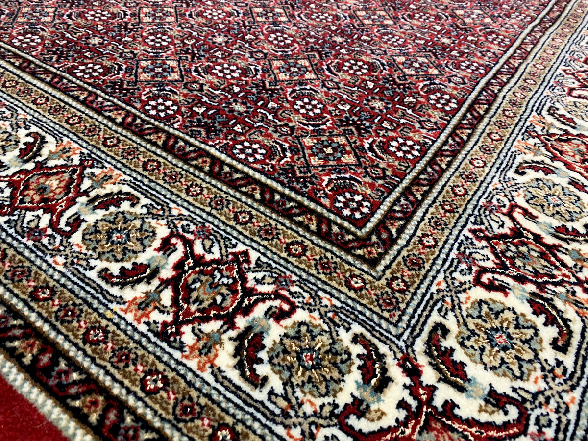 Bidjar rug corner detail: ornamental border, dark red, cream, and black