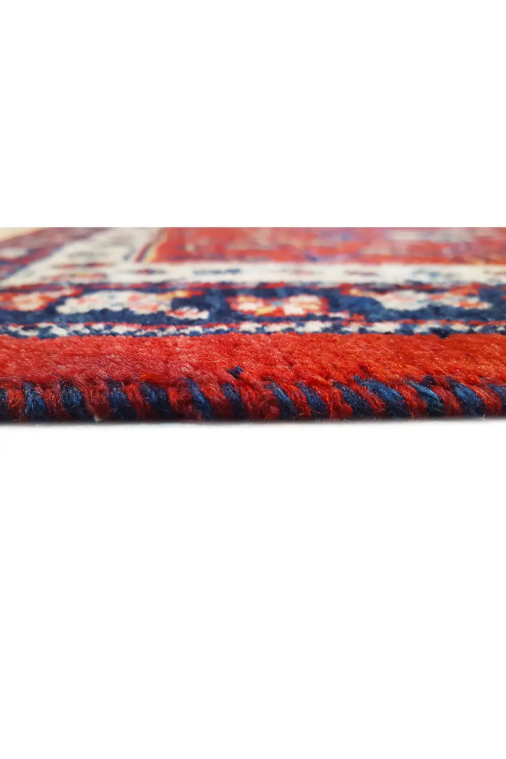 Fringes and floral view of a red carpet with a blue border pattern