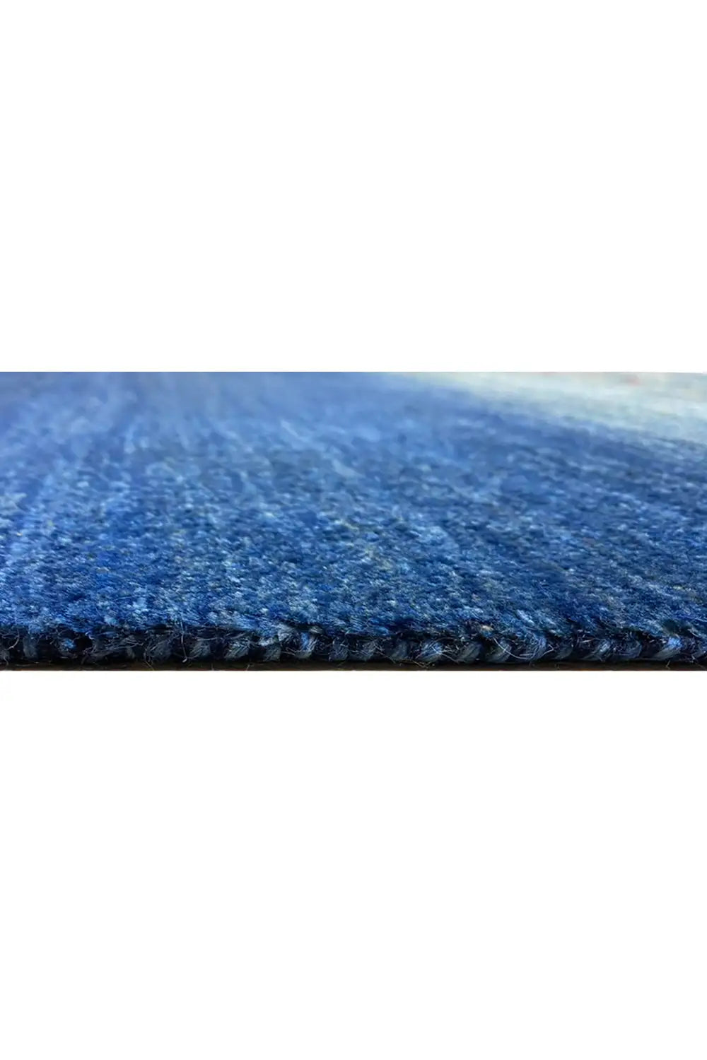 Close-up of the carpet edge: short blue pile with a dense woven texture