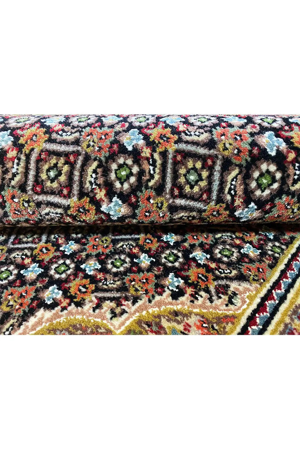 Detailed view of a rug with colorful floral ornaments, a black background, and a decorative border