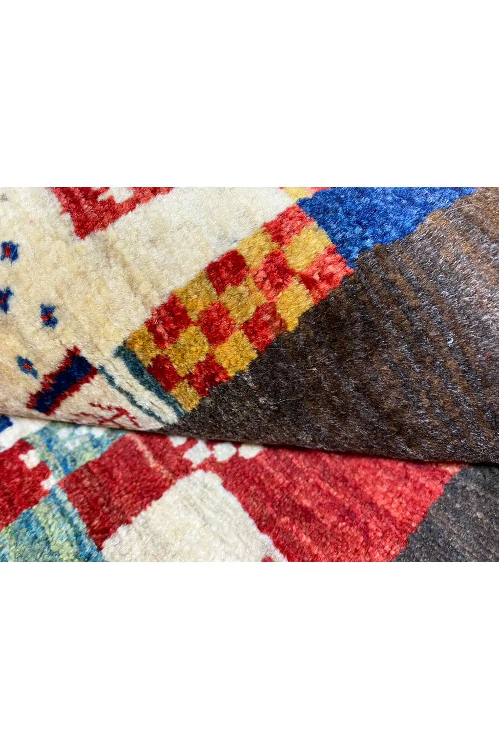 Gabbeh rug 169x107 cm, close-up of the woven edge and patchwork motifs in red, blue, and beige