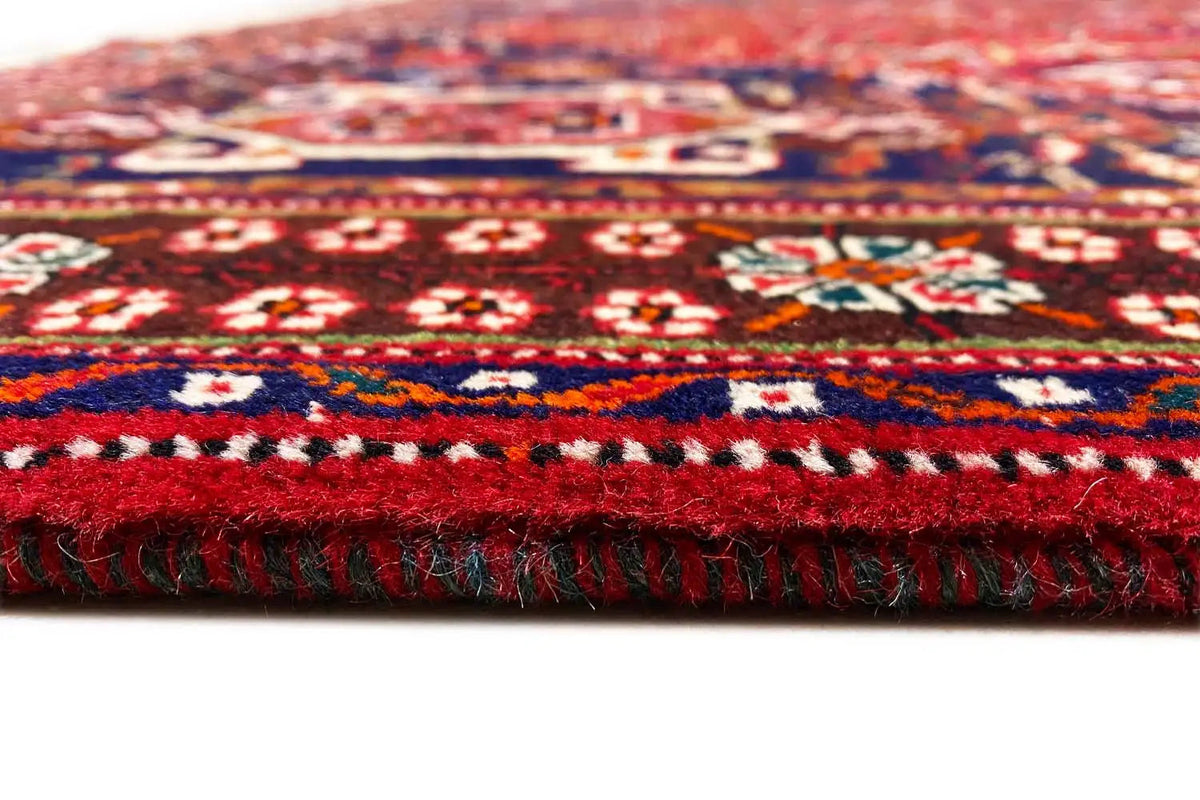 Rug edge with fringe; red-blue pattern on tightly woven fabric