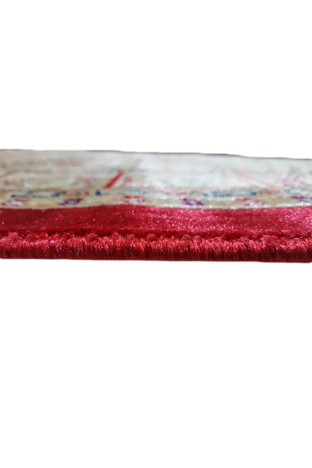 Machine-woven rug: red-edged border with dense pile fringe in close-up detail