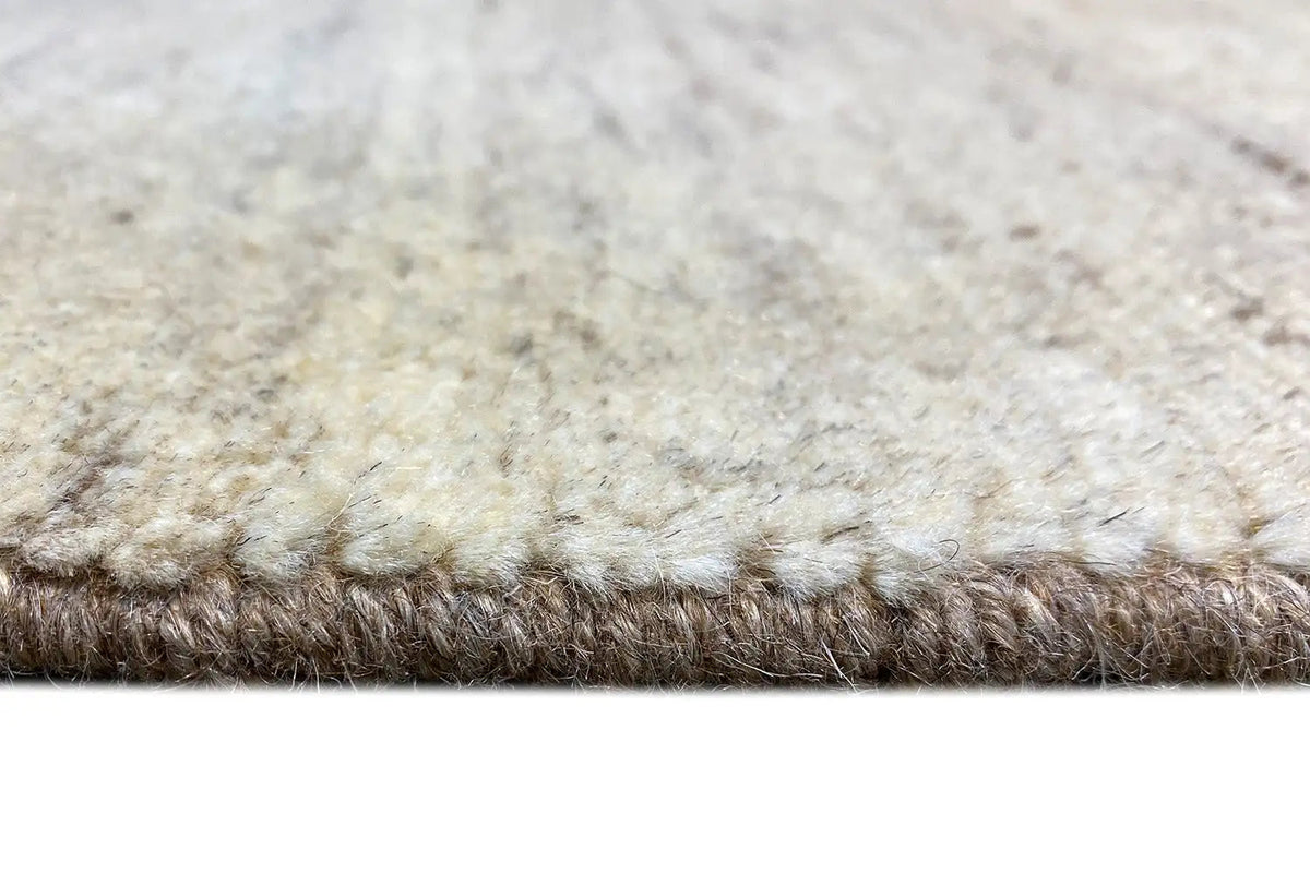 Carpet pile with a dense short texture, light beige surface, and brown border section