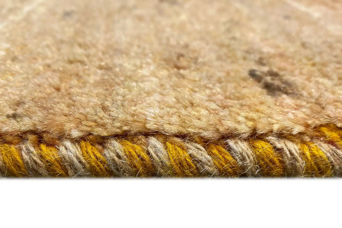 Gabbeh rug, detail of honey-brown wool with fringes and a blue accent