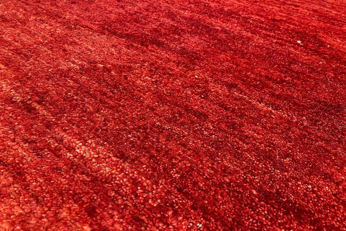 Gabbeh rug, red pile with a dense, fine texture in close-up detail, 110x73 cm.