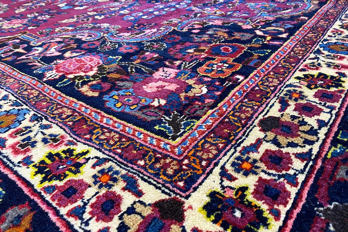 Carpet detail: dark blue background, colorful ornaments, and a red-bordered medallion