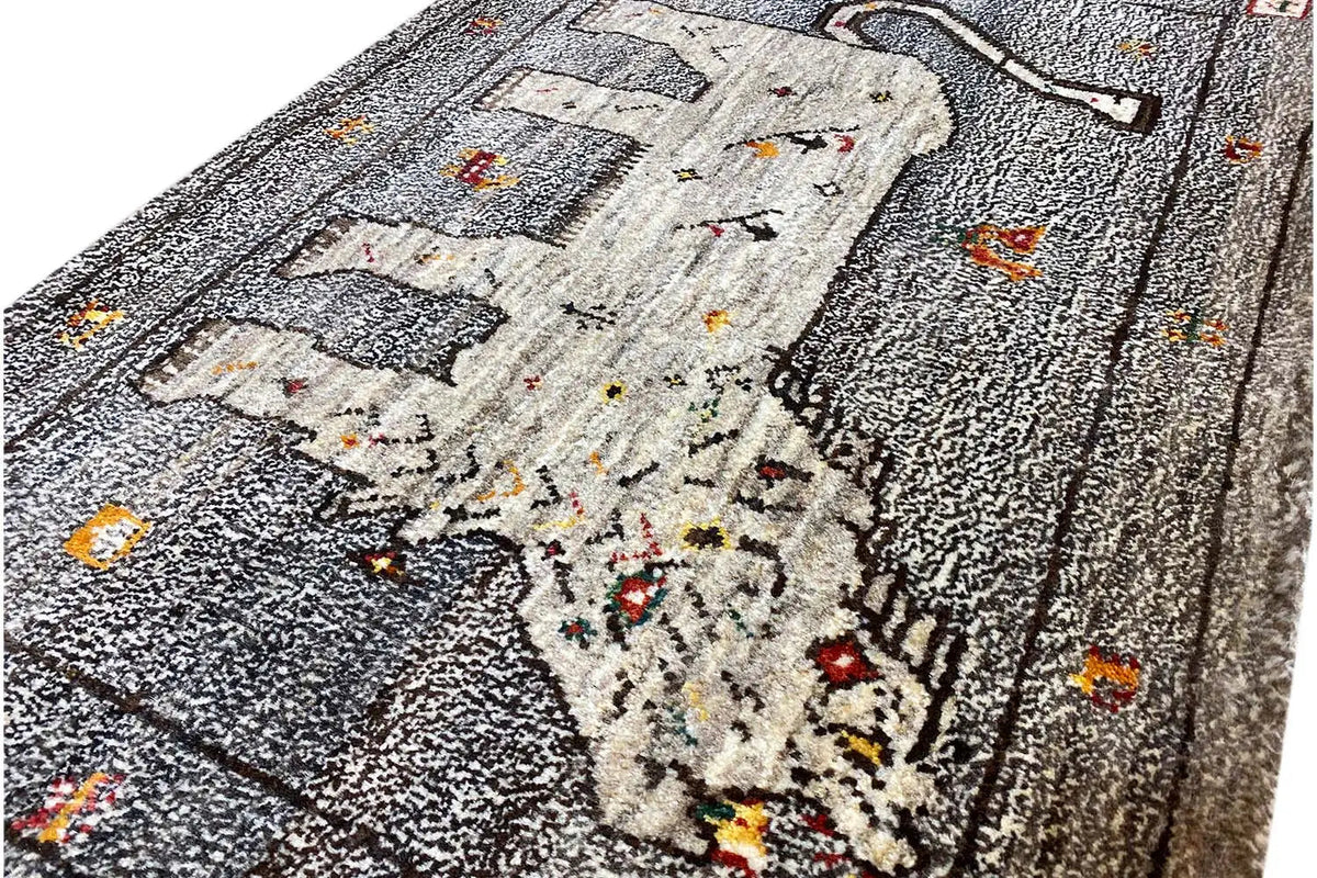 Close-up of Gabbeh rug: lion motif and colorful dots on a gray background