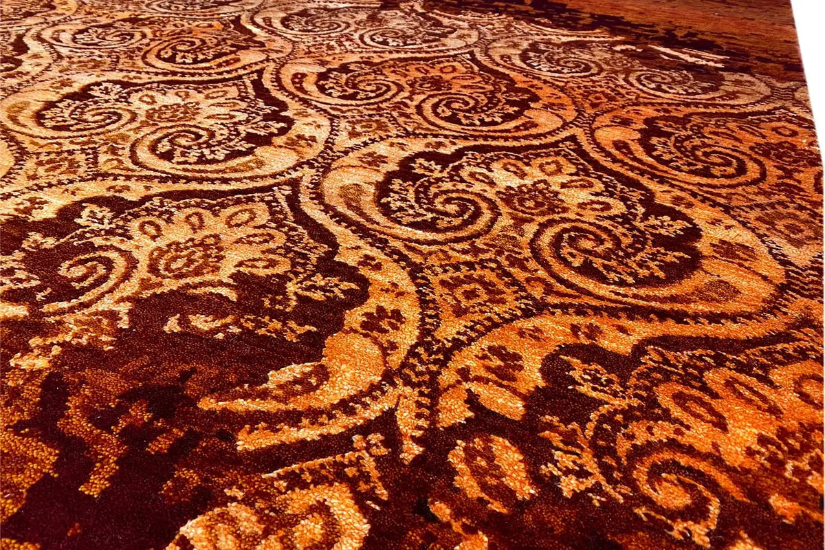 Close-up of the carpet's ornamental pattern in golden brown on a burgundy pile