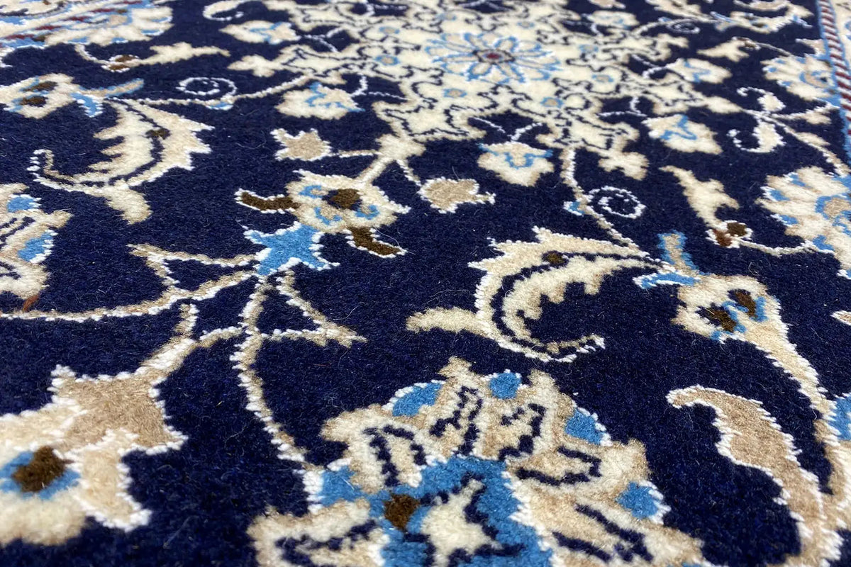 Close-up: dark blue textile pattern with light lines and floral motifs