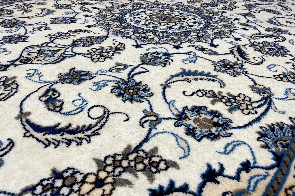Close-up of carpet fabric: blue floral pattern on a light background, fine texture