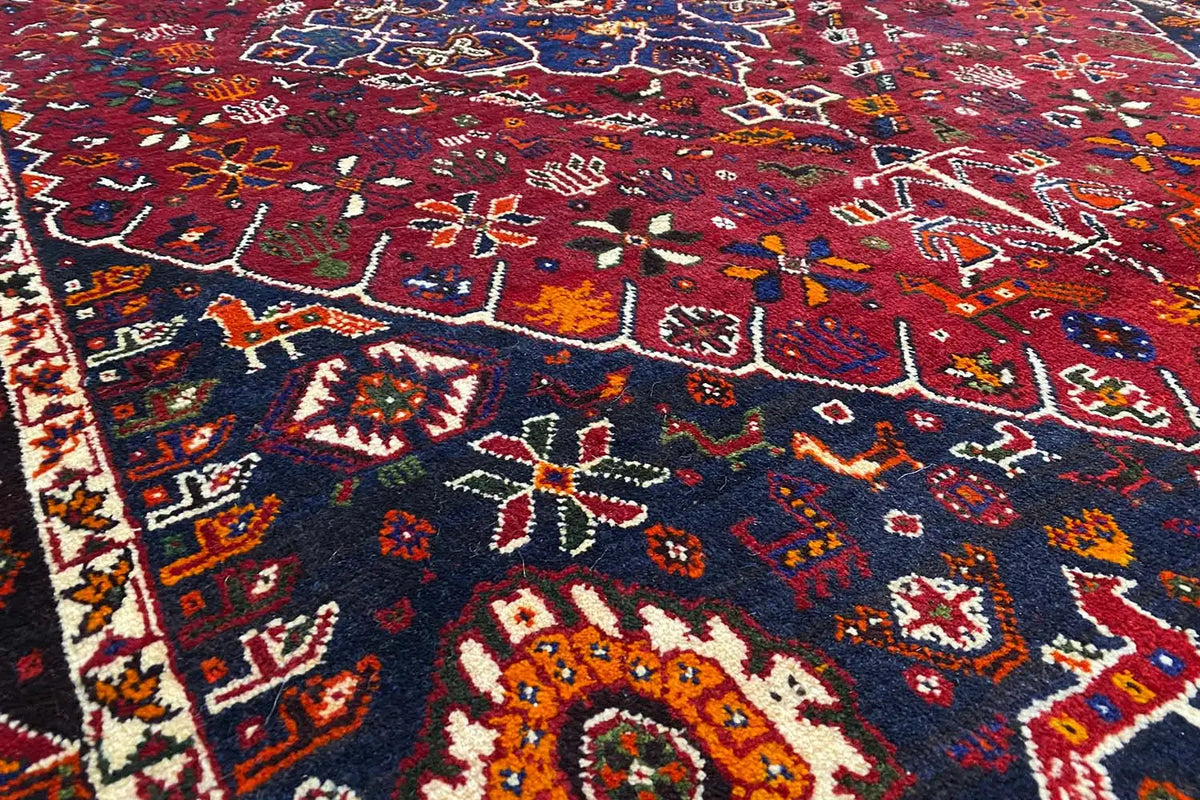 Close-up: red carpet with an intricate ornamental pattern in blue, yellow, and white