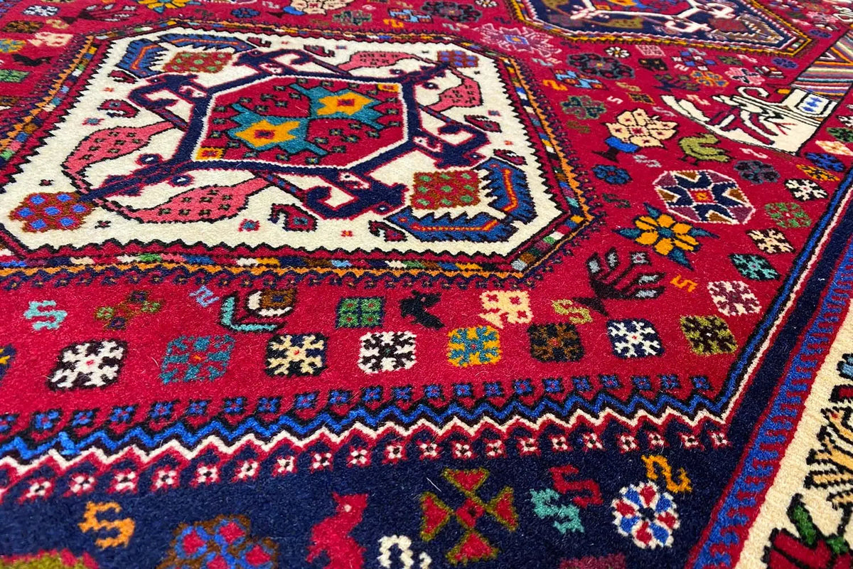 Carpet detail: central motif with multicolored symbols on red, blue border.