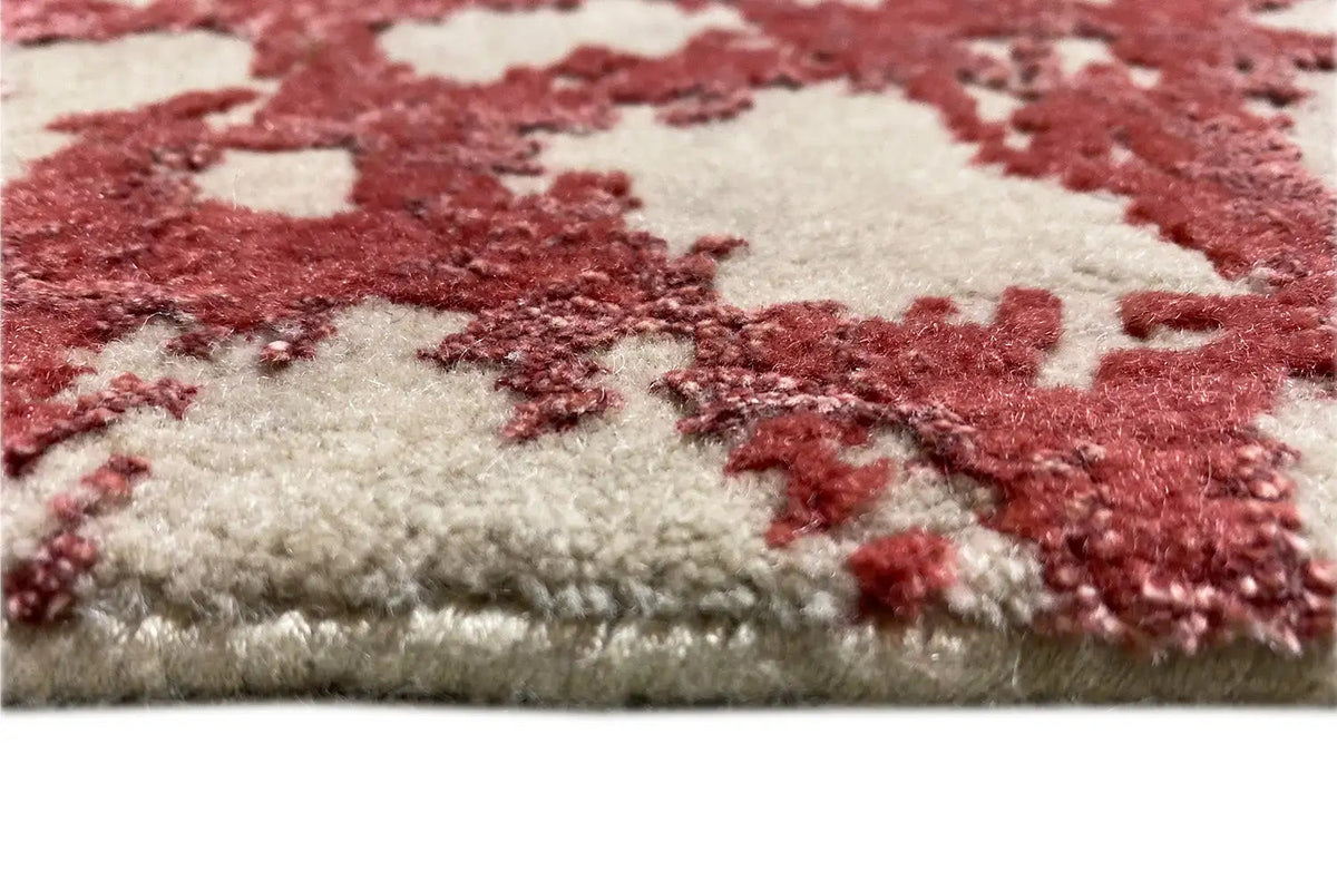 Close-up of carpet pile with a red and cream-colored ornament