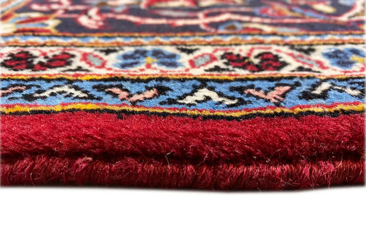 Keshan rug close-up of the pile, rich red with a multicolored border
