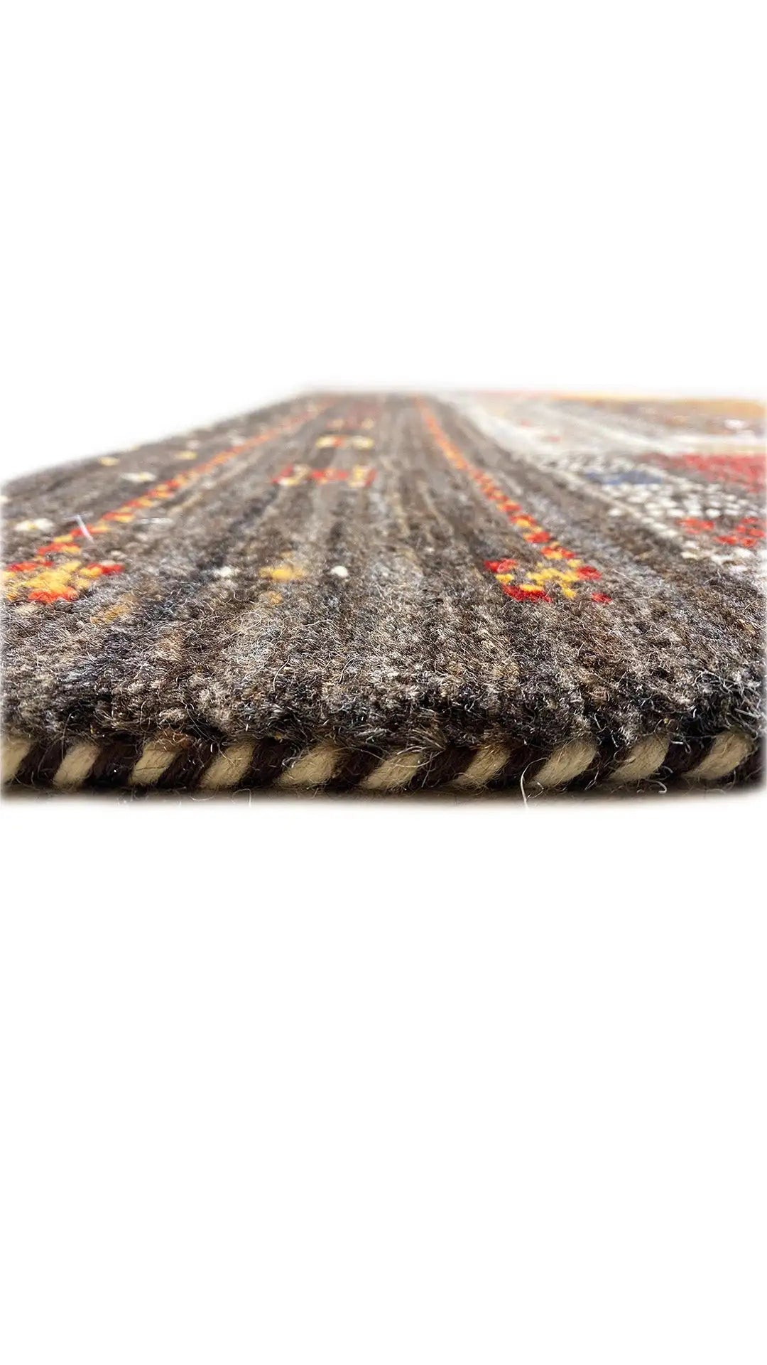 Gabbeh rug, close-up of the pile height at the rolled edge, dark with colorful accents