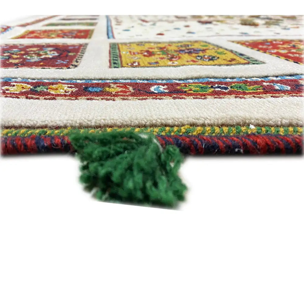 Rug edge with fringe and a multicolored pattern, including green tassels