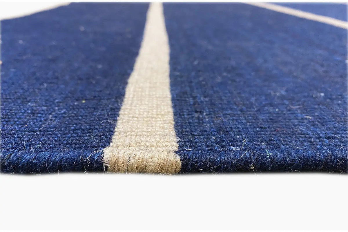 Detail of the kilim: dark blue pile with a beige fringe seam along the edge.