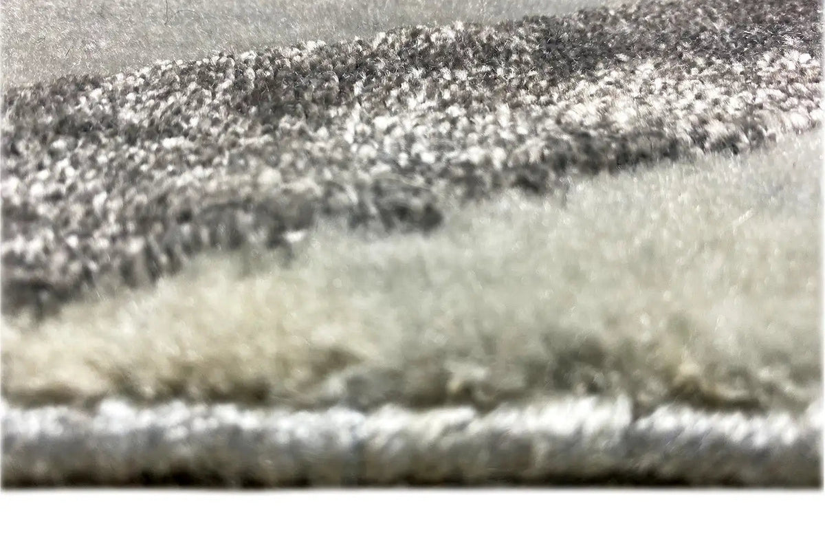 Close-up of the carpet pile: short, patterned pile in shades of gray and dark tones