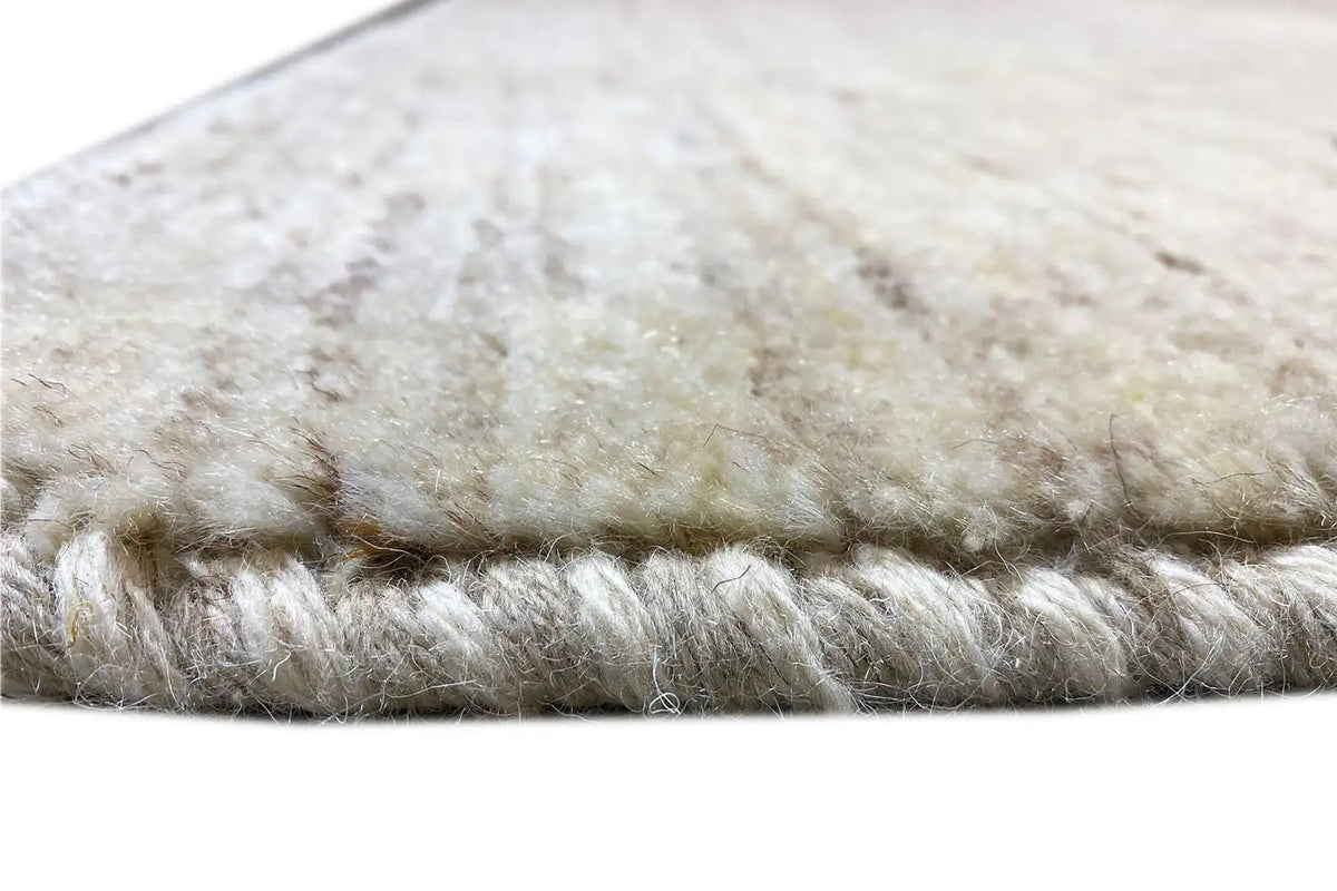 Beige Gabbeh rug with short pile and sewn edge in detail