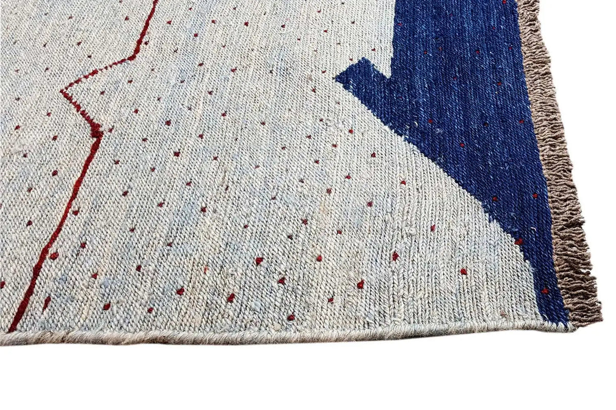 Kilim rug with a light background, blue corner, and red gradients, with fringes