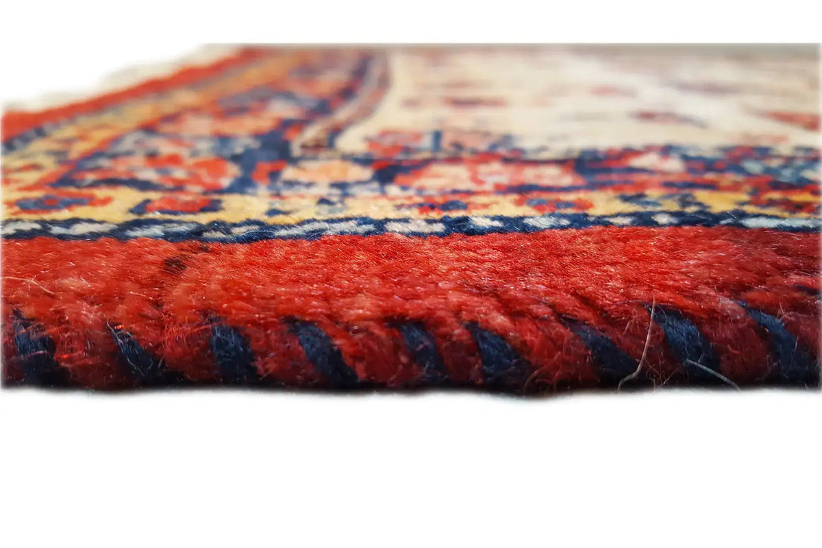 Rug edge with fringe: red tassels and dark blue trim