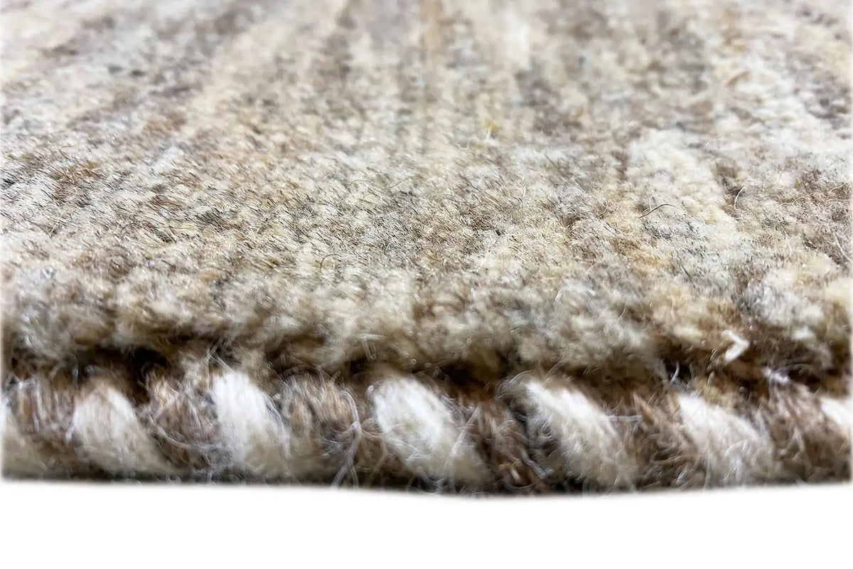 Gabbeh rug close-up: soft pile and fringed edge in gray and cream