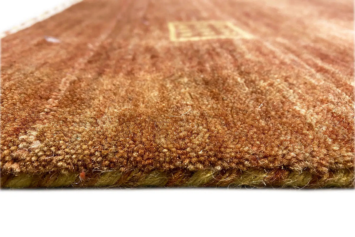 Close-up view of a brown Gabbeh rug with a fine woven surface