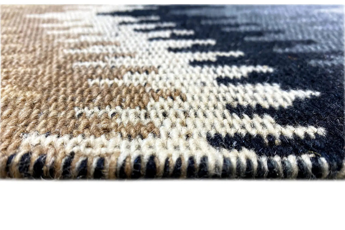 Close-up of a kilim rug: woven zigzag pattern and short fringe along the edge