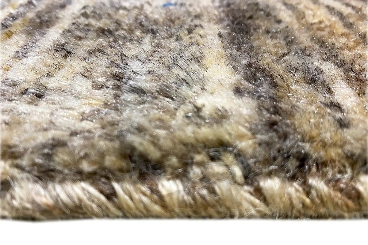 Close-up: beige Gabbeh rug pile with blue and red threads and a patterned texture