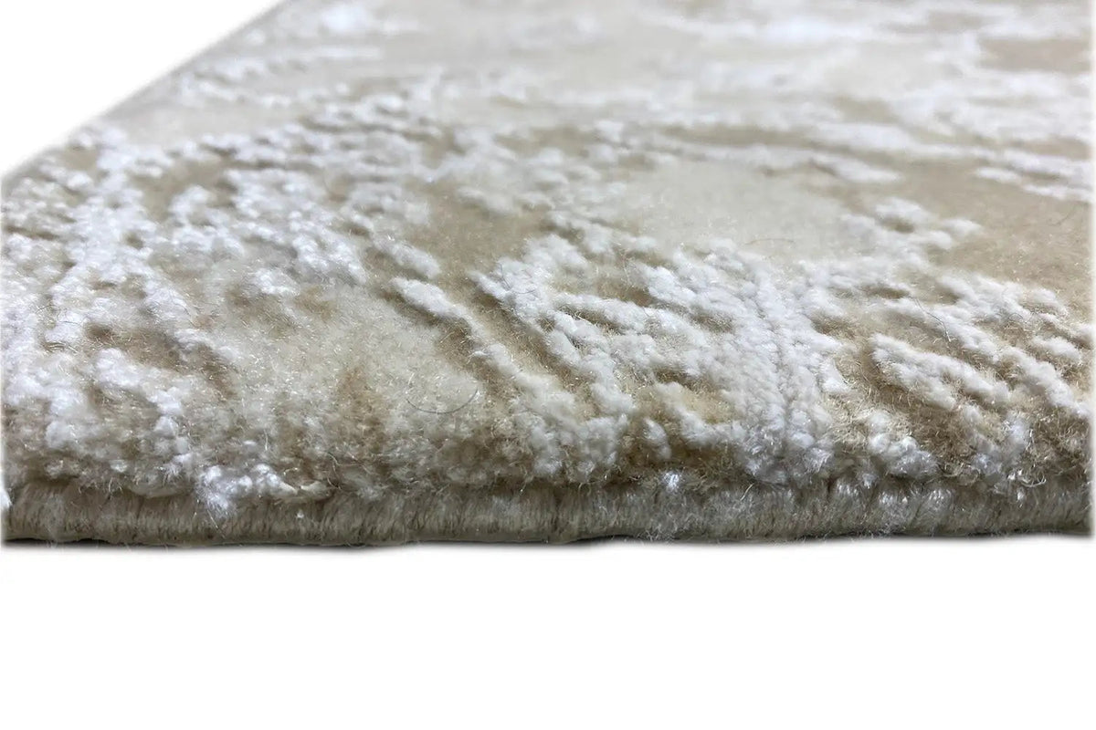 Designer rug edge view: beige pile with a white pattern and short pile height