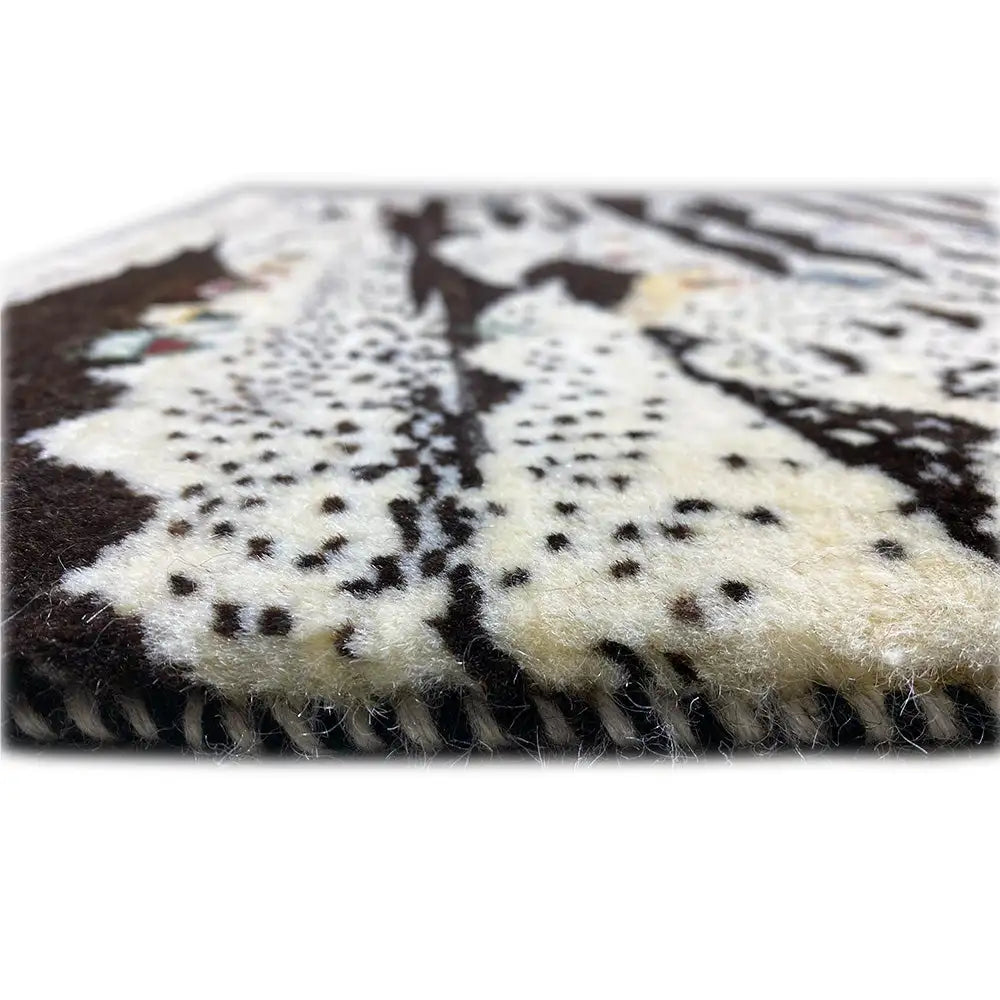 Gabbeh rug with pile along the edge; cream-and-black pattern with colorful accents