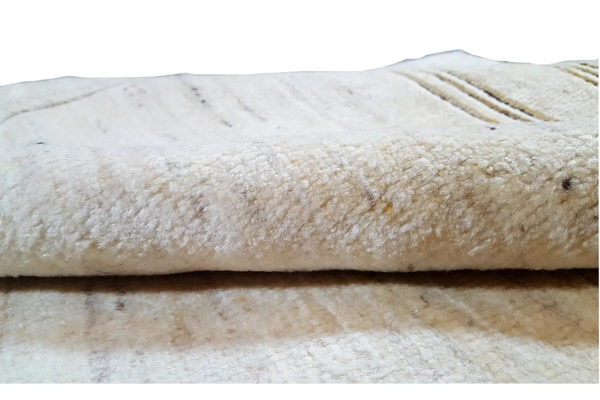 Gabbeh rug close-up of the texture: dense beige pile with a linear texture