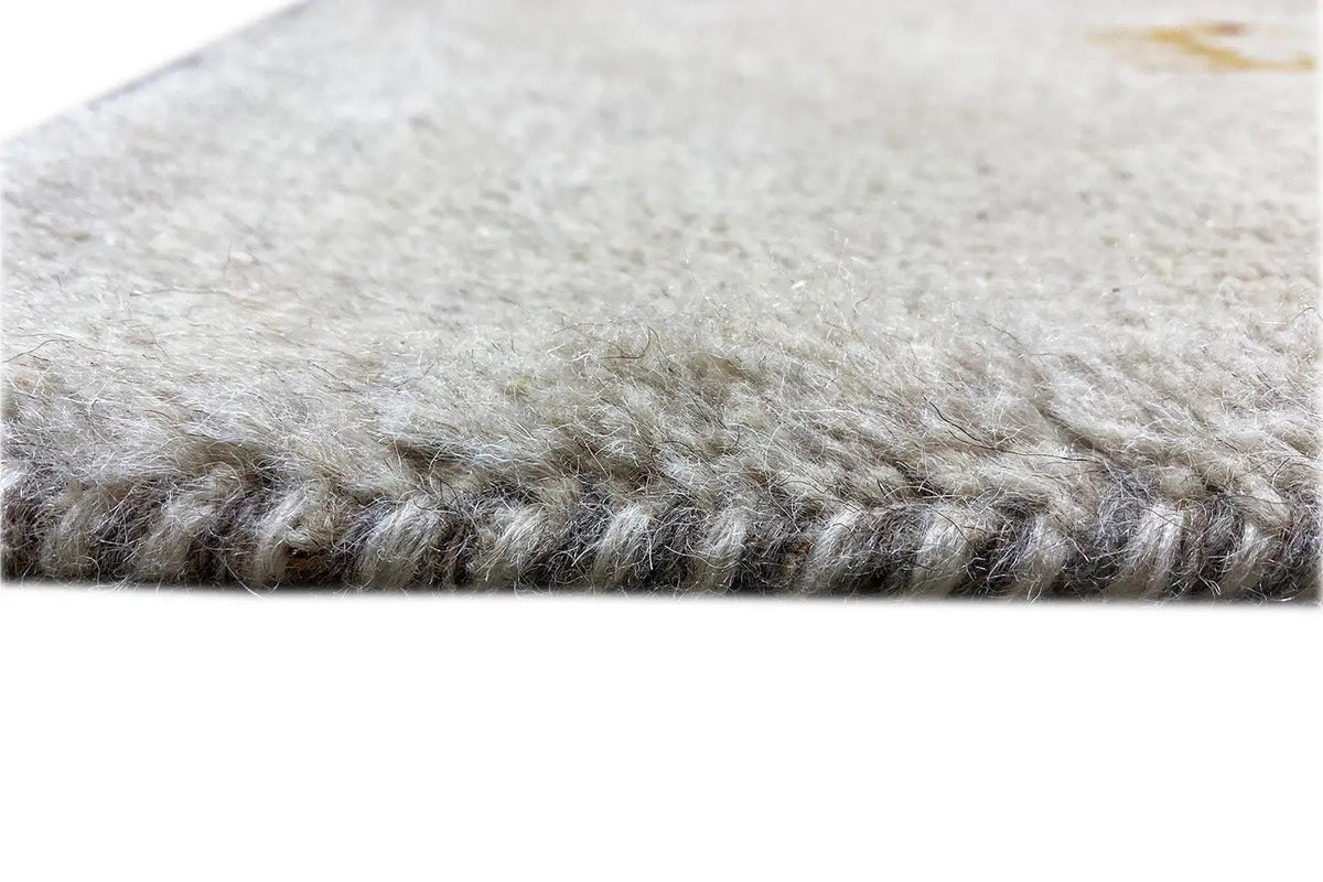 Carpet edge with light gray pile and short fringes