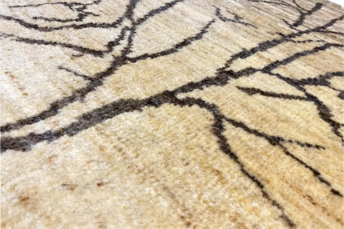 Close-up: beige Gabbeh Lori rug with dark lines and a dense woven texture