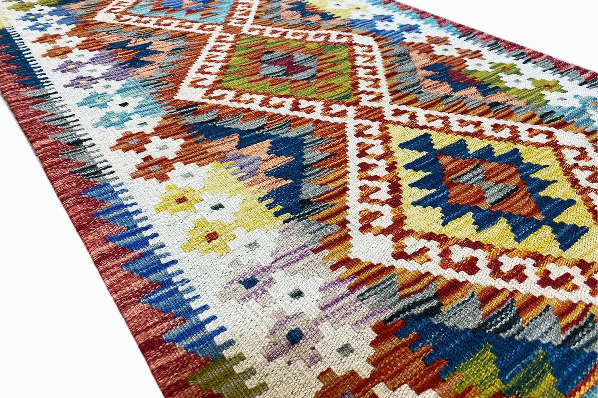Close-up: kilim runner with colorful squares, diamonds, and border, flat-weave texture