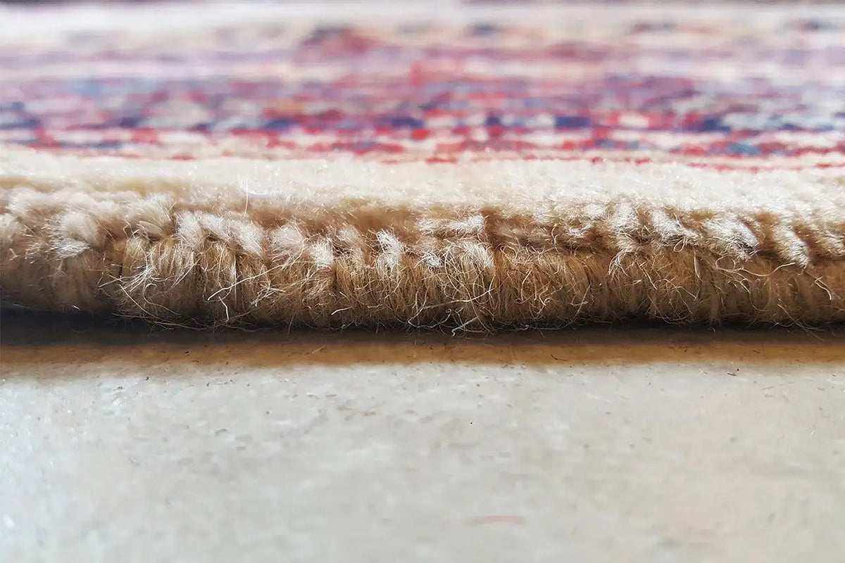 Carpet edge with hand-knotted pile and frayed hem