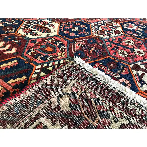 Persian carpet detail with fringed edge and ornaments, red, blue, beige