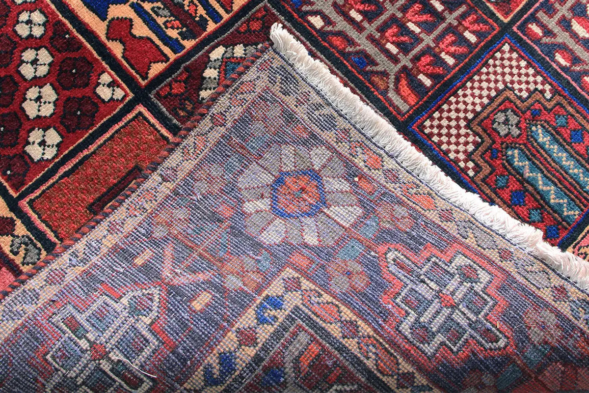 Close-up of the rug’s edge: a light woven pattern in blue, red, and cream with fringes