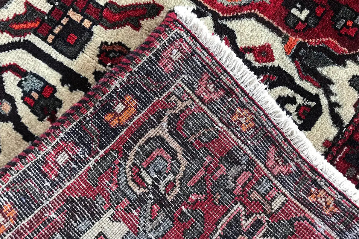 Carpet detail with a woven texture and diagonal patterns in red and dark blue