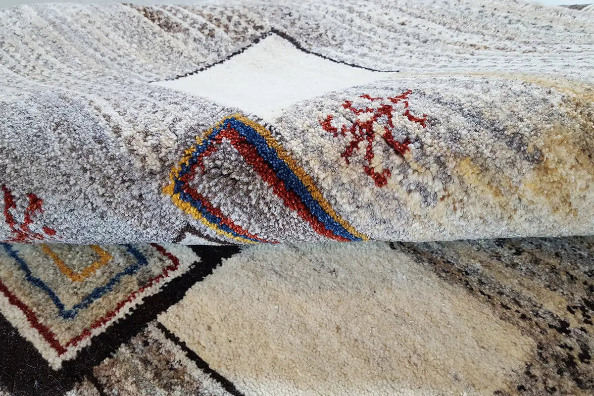 Gabbeh rug with multicolored decorative patterns on a beige background, close-up
