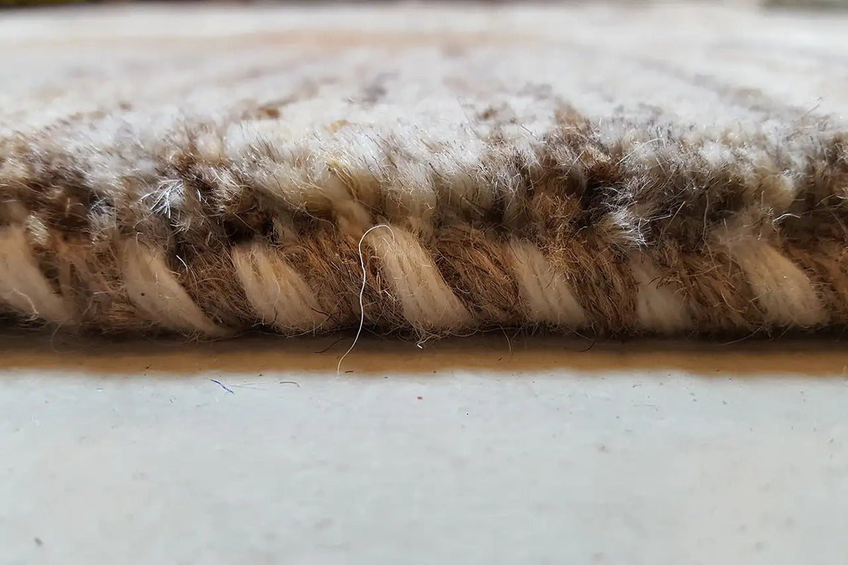 Gabbeh rug, edge view: dense pile with brown-beige fibers