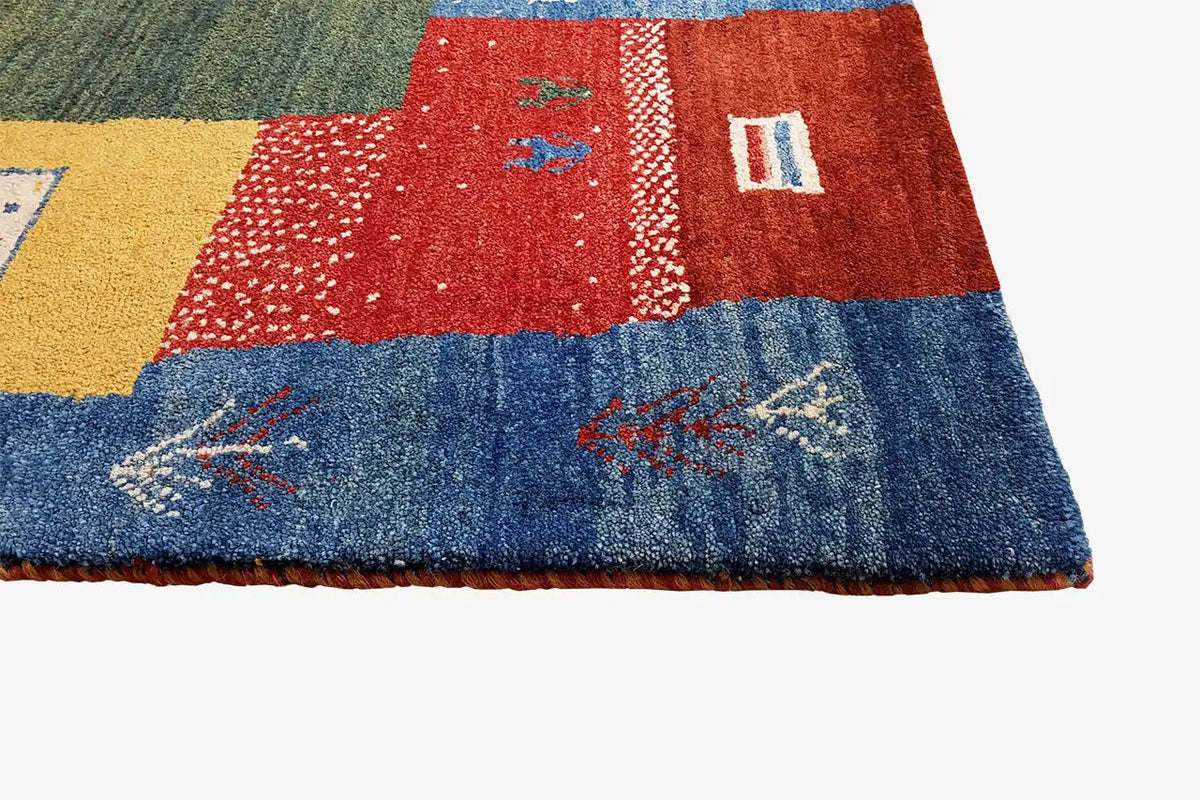 Lower edge of a Gabbeh rug with patchwork: red, blue and yellow sections with ornaments
