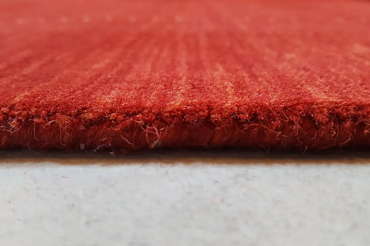 Red carpet edge with dense pile and neatly bound border, close-up