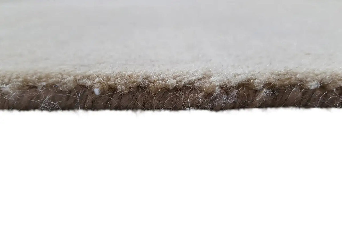 Rug edge with a high pile, gray on top, light beige underneath