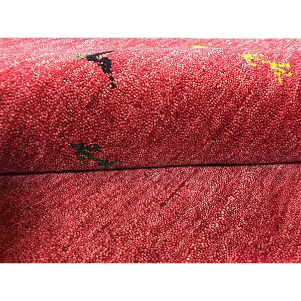 Red Gabbeh rug with dense pile; animal motifs in black, yellow and green