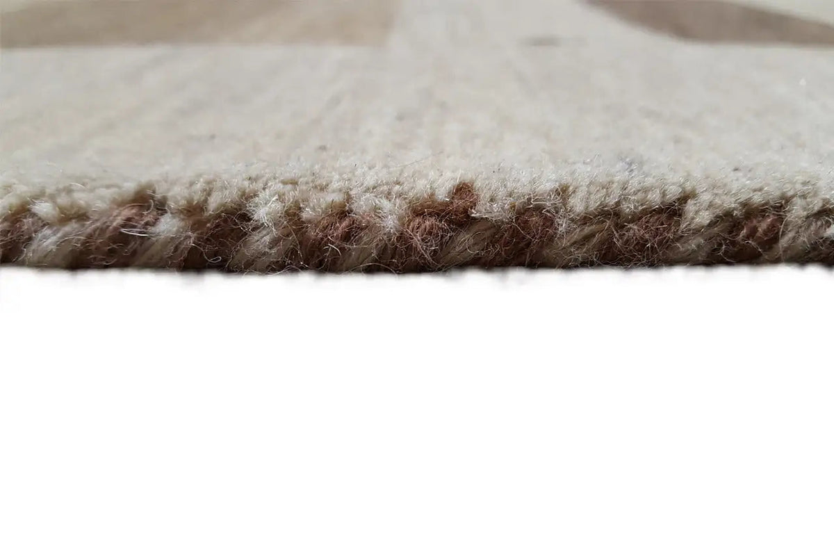 Carpet edge with beige pile and brown border, close-up side view