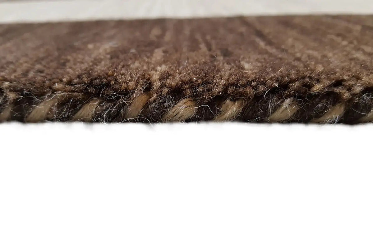 Gabbeh rug: pile detail at the edge, dark brown and light beige in cross-section