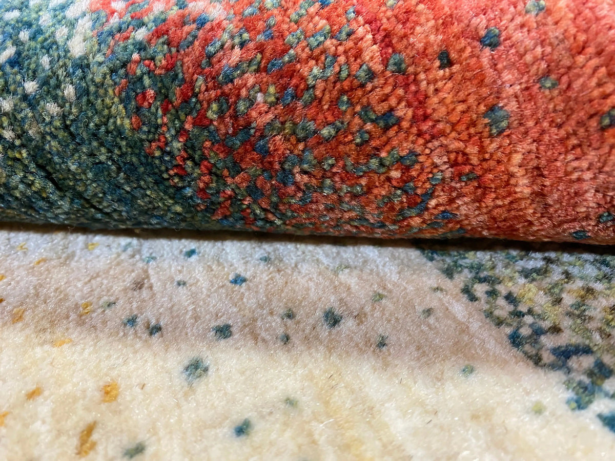 Detail of the Gabbeh rug: hand-pressed virgin wool texture in orange, red and teal