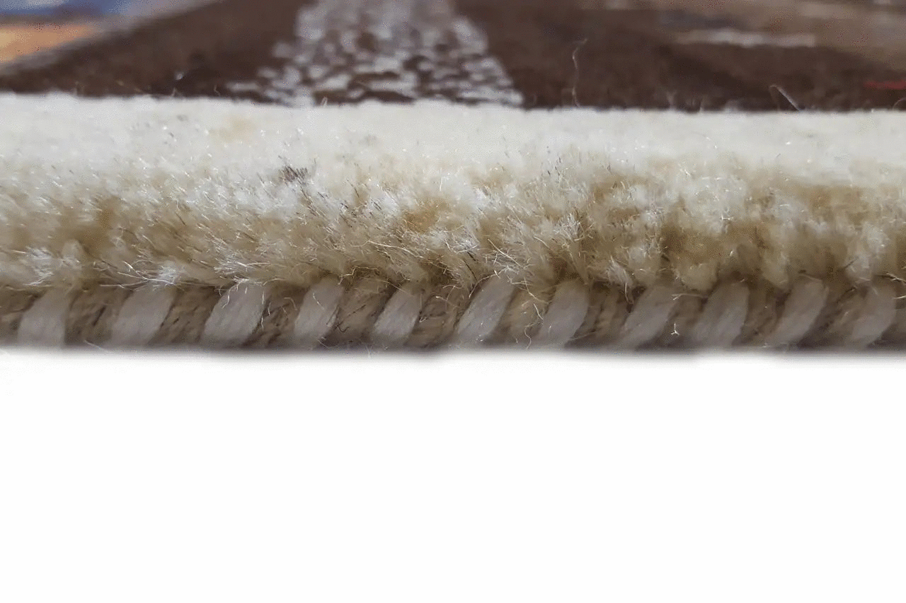 Carpet edge with a beige fringe trim and brown fabric weave
